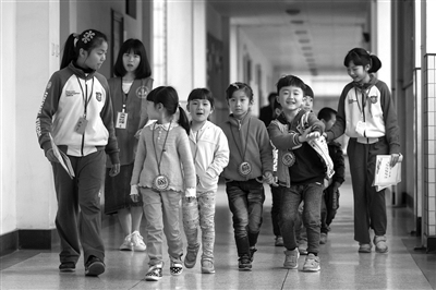 昨天上午，锦绣育才附属小学报名点，参加面谈的孩子在六年级学生带领下前往各教室。 